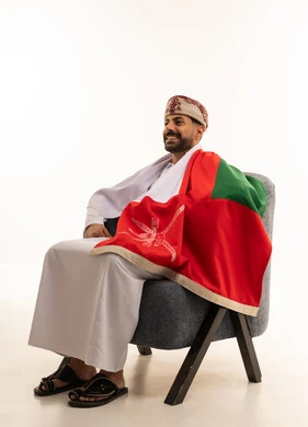 Omani Man in Traditional Dress with National Flag