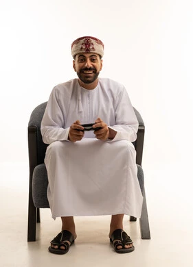 Omani Man with Game Controller in Traditional Dress