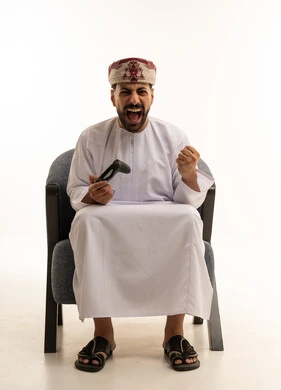 Omani Man Gaming with Excited Expression on White Background