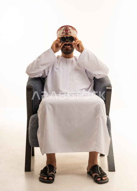 Omani Man in Traditional Dress Using Binoculars