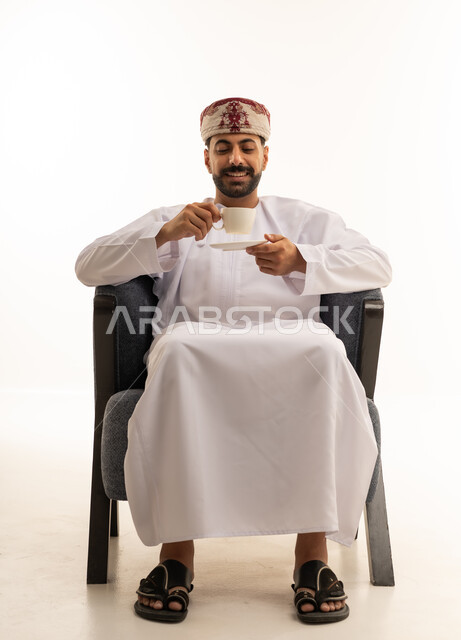 رجل عماني بالزي التقليدي يشرب القهوة