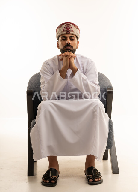 رجل عماني بالزي التقليدي يجلس في الاستوديو