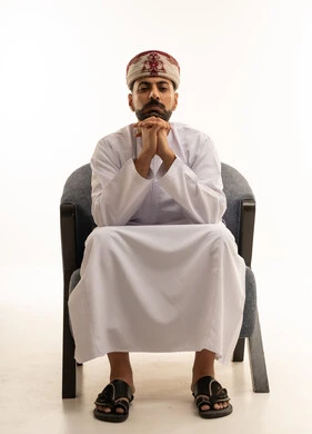 Omani Man in Traditional Dishdasha Sitting in Studio