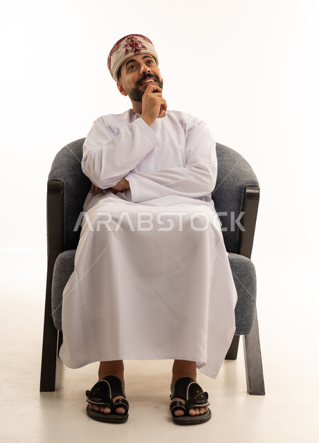 رجل عماني بالزي التقليدي في وضعية تفكير