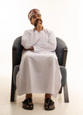رجل عماني بالزي التقليدي في وضعية تفكير