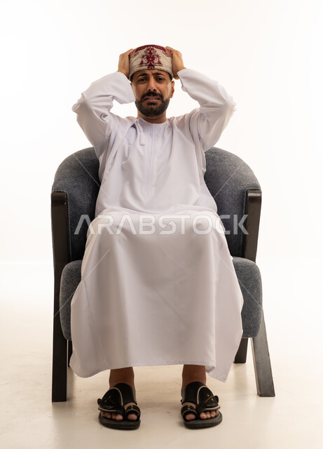 رجل عماني بزي تقليدي يشعر بالتوتر والإحباط