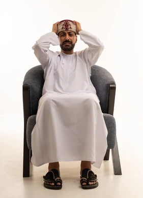 رجل عماني بزي تقليدي يشعر بالتوتر والإحباط