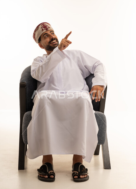 رجل عماني بالزي التقليدي يشير إلى الأعلى
