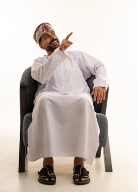 رجل عماني بالزي التقليدي يشير إلى الأعلى