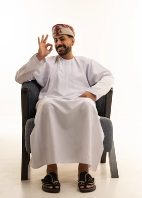 رجل عماني بالزي التقليدي يشير بعلامة الموافقة