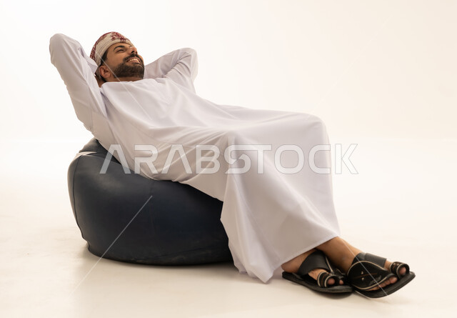 رجل عماني يسترخي على كرسي بين باج خلفية بيضاء