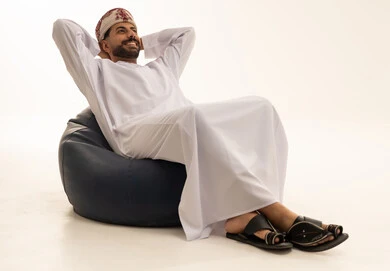 Omani Man Relaxing on Bean Bag in Traditional Dress