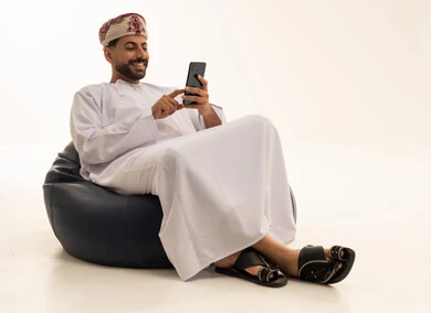 Omani Man in Traditional Dress Using Smartphone