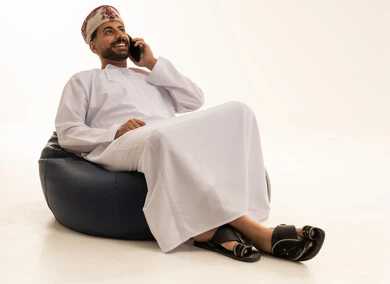 رجل عماني يتحدث بالهاتف المحمول بالزي التقليدي