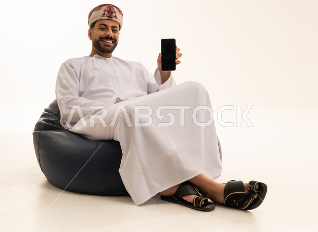 Omani Man with Smartphone on Beanbag Chair