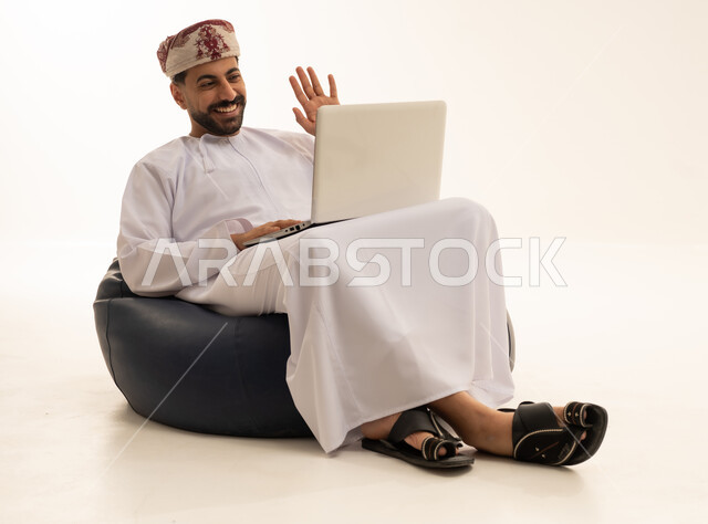 رجل عماني يستخدم المحمول ويلوح بخلفية بيضاء
