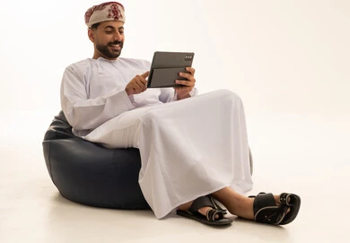 Omani Man Using Tablet on Beanbag Studio Shot