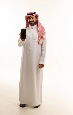 رجل سعودي بالثوب التقليدي يمسك هاتف جوال