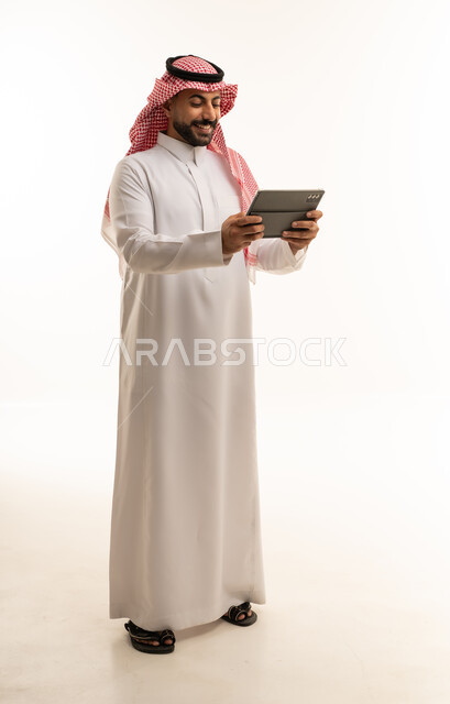 Saudi Man in Thobe Using Digital Tablet