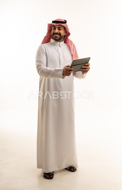 Saudi Man in Traditional Thobe Holding Digital Tablet