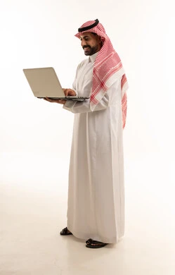 Saudi Man in Traditional Thobe Using Laptop
