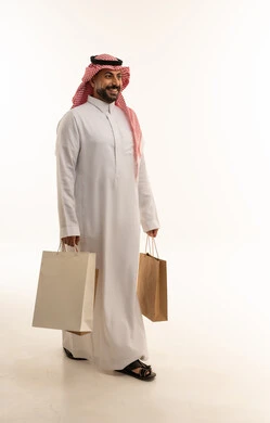 Saudi Man Walking with Shopping Bags on White Background