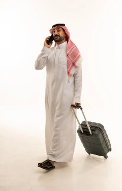 رجل سعودي بالثوب التقليدي يحمل حقيبة سفر