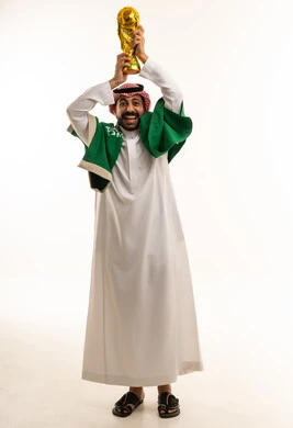 رجل سعودي يحمل كأس كرة القدم مع العلم الوطني