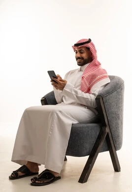 Saudi Man in Traditional Thobe Using Smartphone