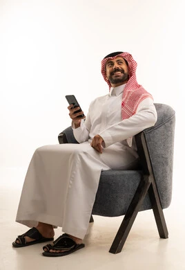 Saudi Man in Traditional Thobe Holding Smartphone