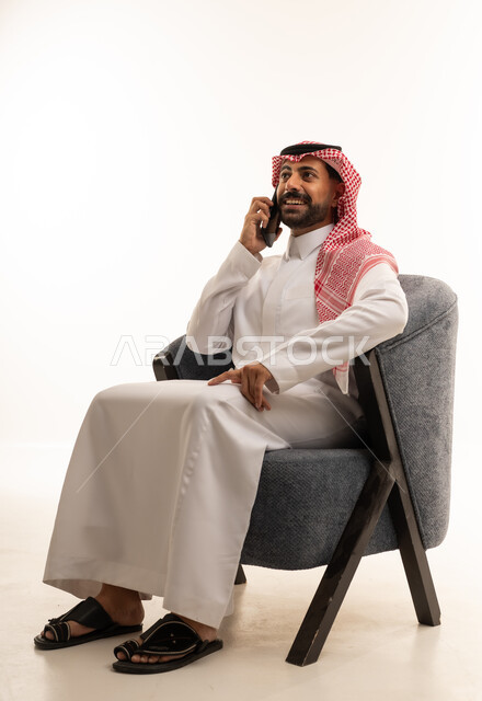 Saudi Man in Traditional Thobe Talking on Phone