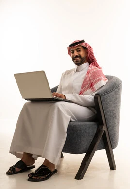 Saudi Man Using Laptop in Traditional Clothing