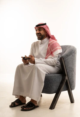 Saudi Man Gaming on Armchair in Studio