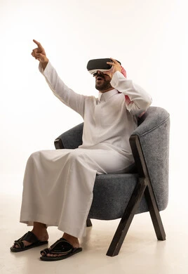 رجل سعودي بالثوب التقليدي يستخدم نظارة الواقع الافتراضي