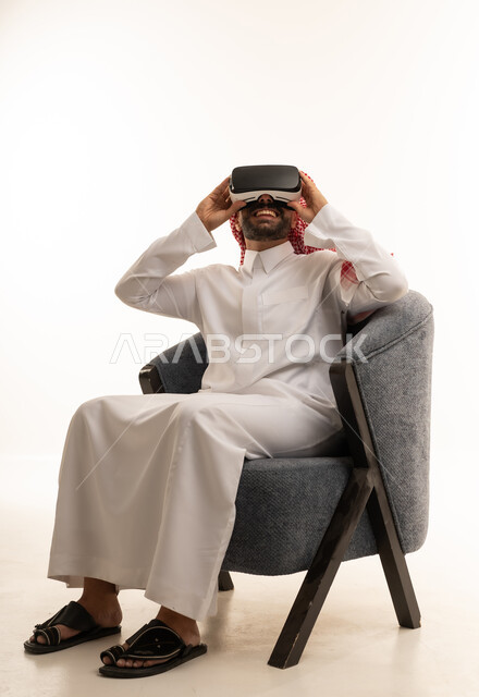 رجل سعودي بالثوب يستخدم سماعة الواقع الافتراضي