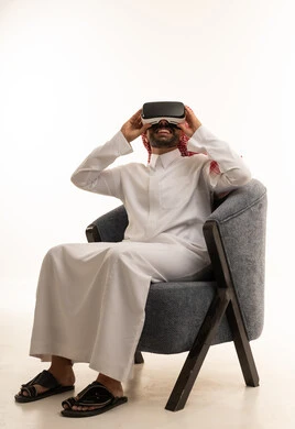رجل سعودي بالثوب يستخدم سماعة الواقع الافتراضي