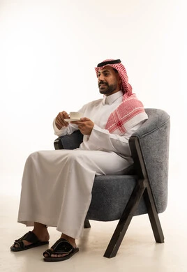 Saudi Man in Traditional Thobe Sitting with Coffee