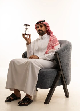 Saudi Man in Traditional Dress Holding Hourglass
