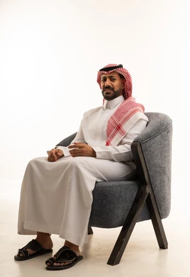 Saudi Man in Traditional Dress Sitting in Modern Chair