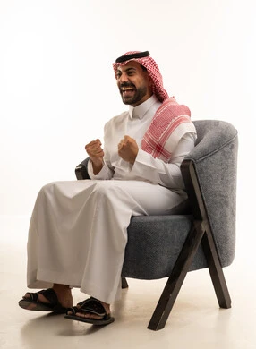 رجل سعودي بالزي التقليدي يحتفل بالفوز والسعادة
