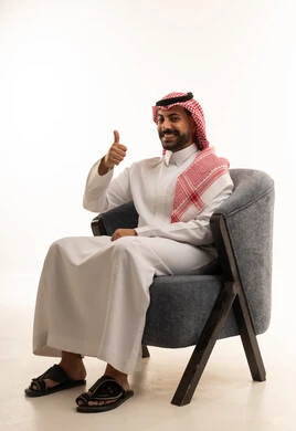رجل سعودي بالثوب والشماغ يرفع إبهامه علامة الرضا