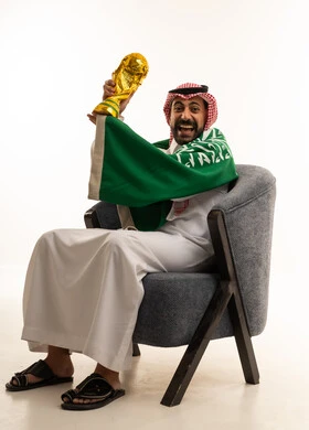 رجل سعودي مع كأس العالم والعلم السعودي