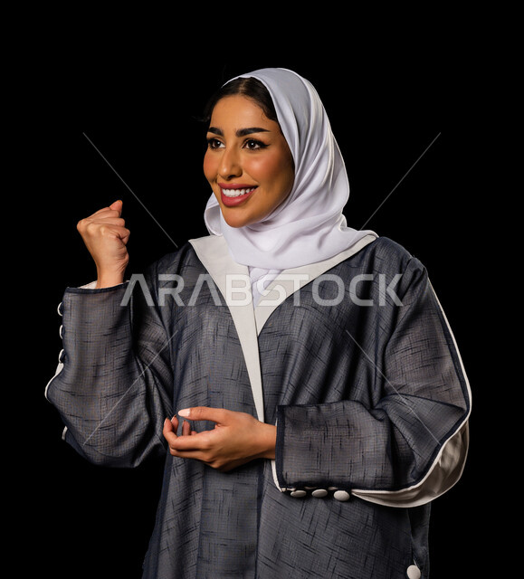 بورتريه لسيدة عربية خليجية سعودية بإيماءات و تعابير وجه و يدين تدل على السعادة و الفوز ، القوة و الانتصار ، أندية و تشجيع ، خلفية سوداء