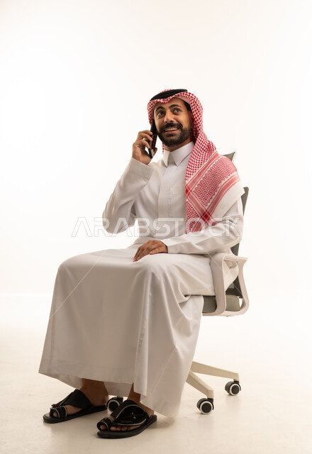 رجل سعودي بالثوب التقليدي يتحدث بالهاتف
