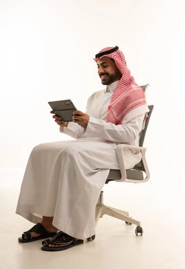 Saudi Man Using Digital Tablet in Office Chair