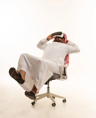 رجل سعودي يستخدم نظارة الواقع الافتراضي بالزي التقليدي