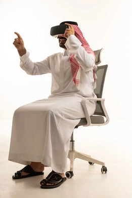 رجل سعودي يستخدم سماعة الواقع الافتراضي بالثوب