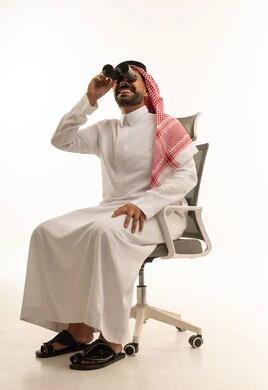 Saudi Man in Thobe Using Binoculars in Office Chair
