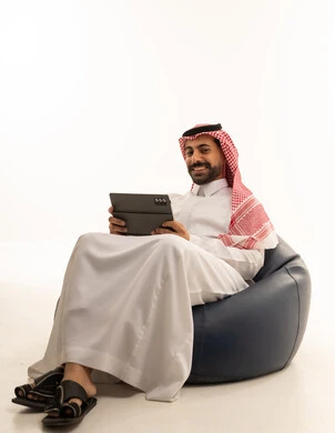 رجل سعودي مع جهاز لوحي على خلفية بيضاء