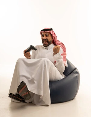Saudi Man Celebrating Video Game Victory on Bean Bag